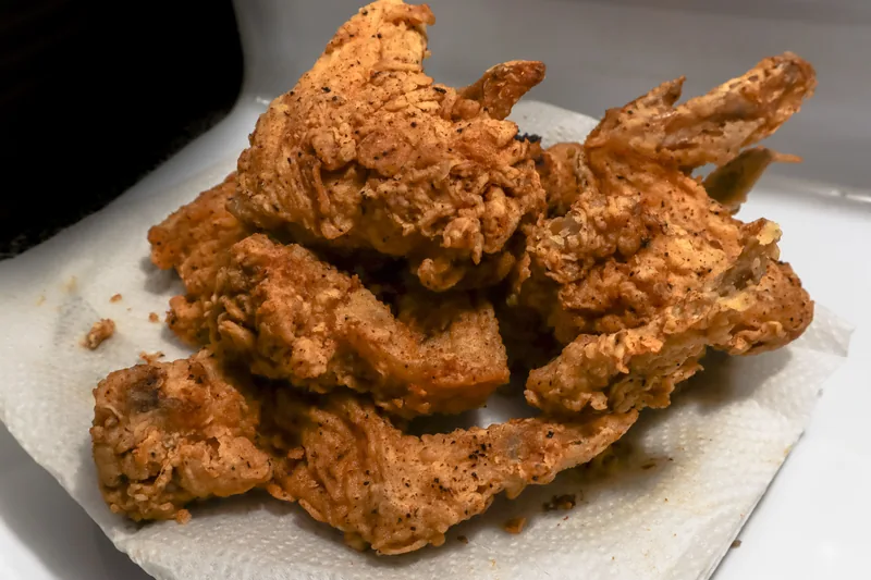 Crisp golden fried chicken pieces resting on paper