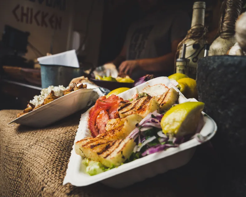 Sliced gyros chicken plated with lemon and red cabbage