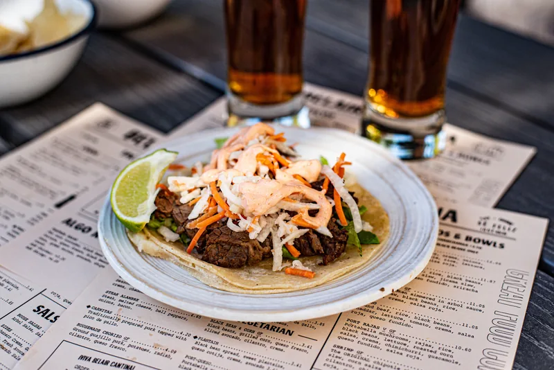 A soft taco piled with shredded slaw and a lime wedge on a plate