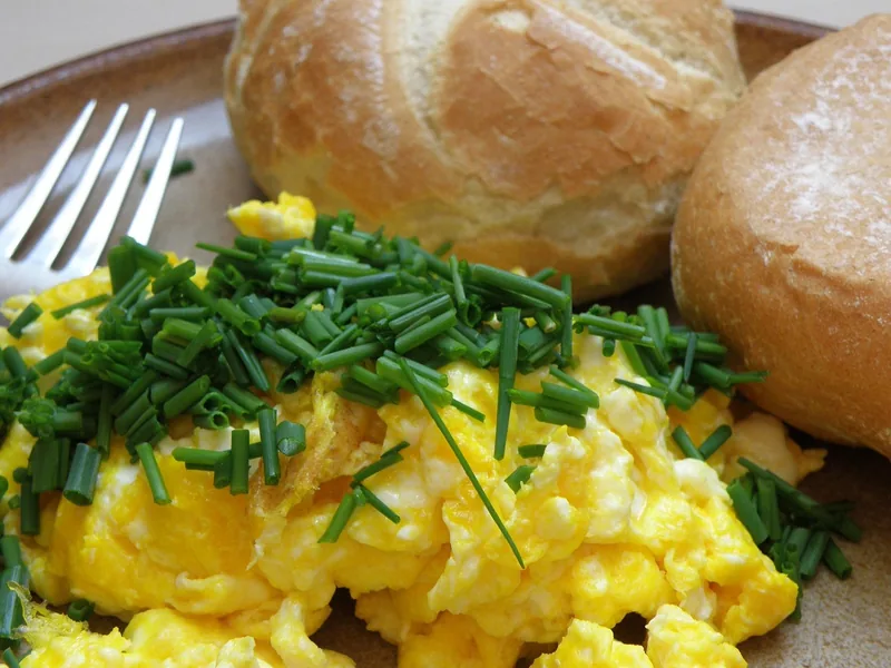 Scrambled eggs with chives and crusty bread rolls