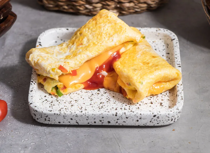 A toasted cheese sandwich cut open, egg and melted cheese inside