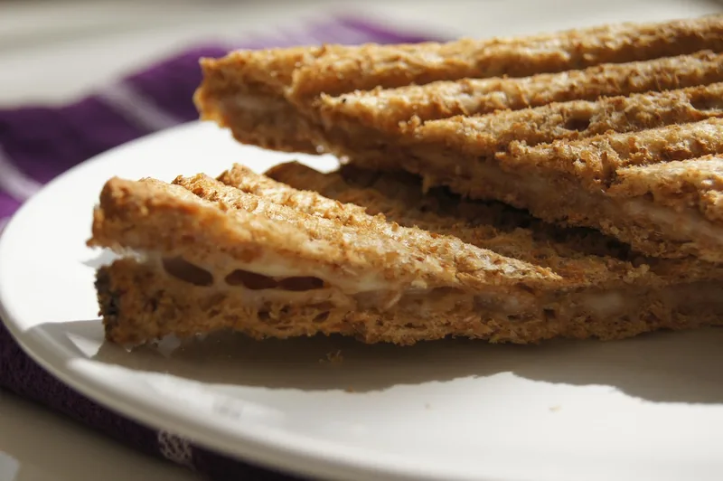 Toasted sandwiches stacked on a plate