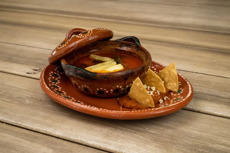 Tortilla soup in a clay bowl with tortilla strips