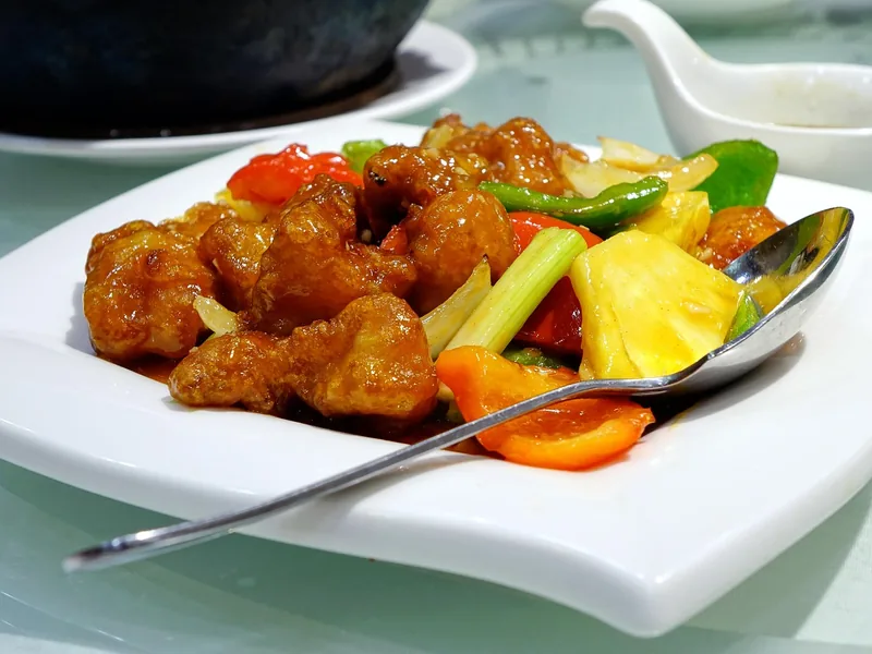 Battered chicken and pineapple coated in glossy sweet and sour sauce