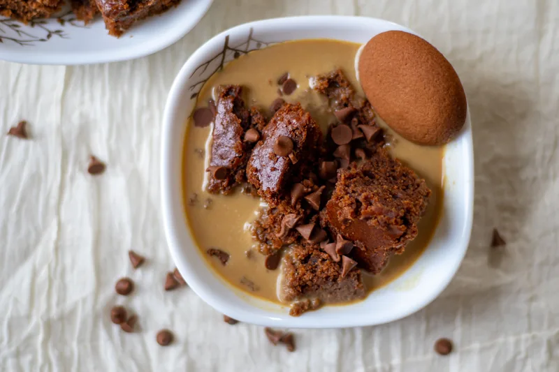 Pieces of chocolate cake sitting in milk in a white dish