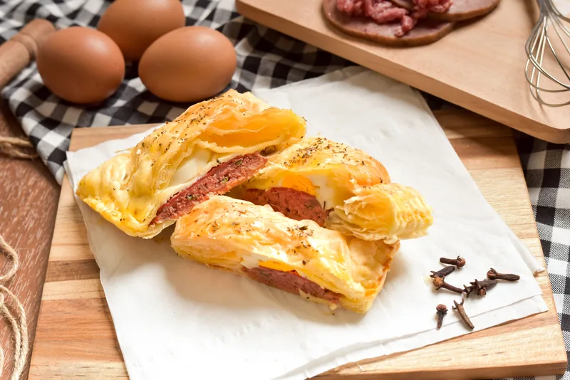 Flaky pastry rolls with a meat filling on a board