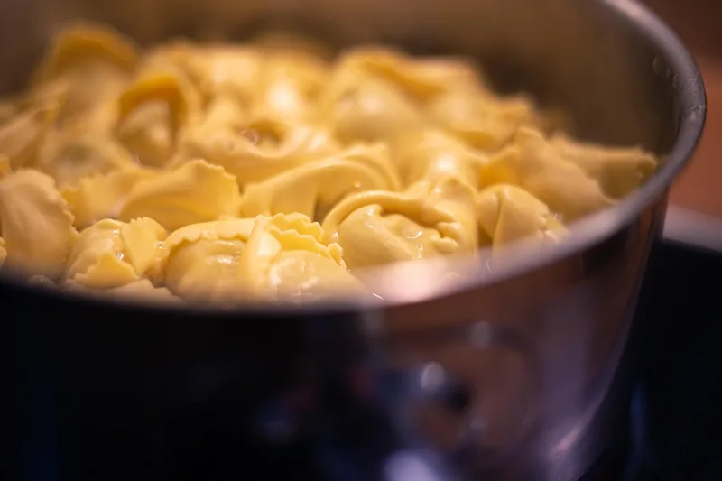 Tortellini cooking in a steaming pot