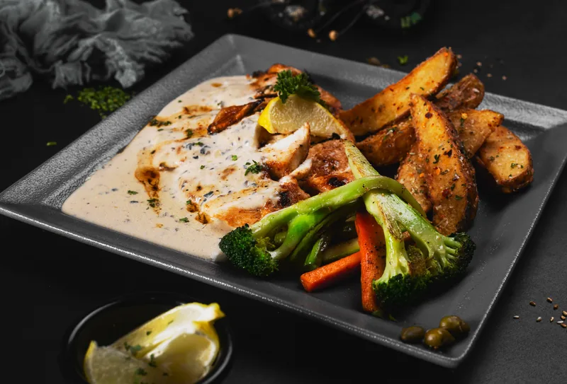 Seared chicken in a cream sauce with broccoli and roasted potatoes