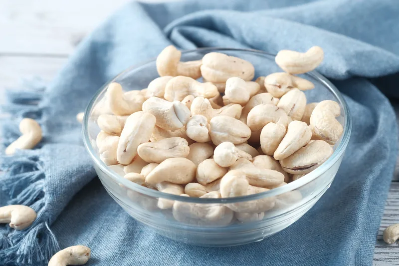 A glass bowl of raw cashews