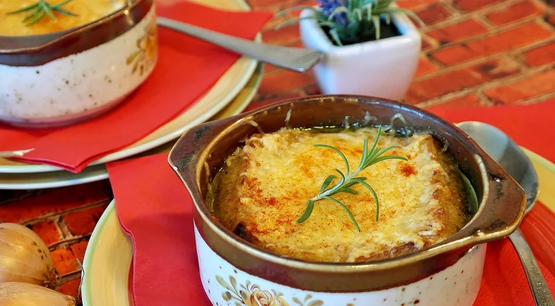 French onion soup in a crock under a browned layer of melted cheese