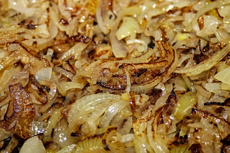 Sliced onions browning slowly in a pan