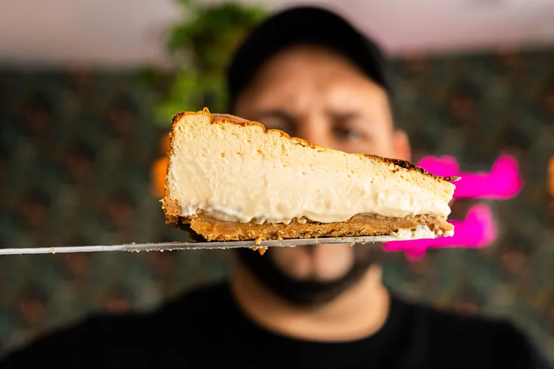 A slice of creamy pale pie on a cookie crust, held up on a server