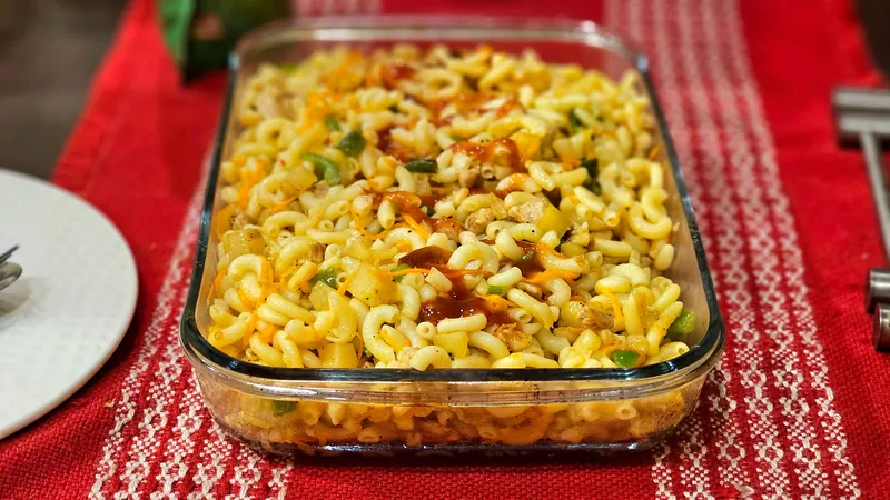 A pasta casserole in a glass baking dish on a red tablecloth