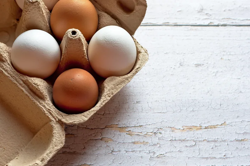 Brown and white eggs in a carton