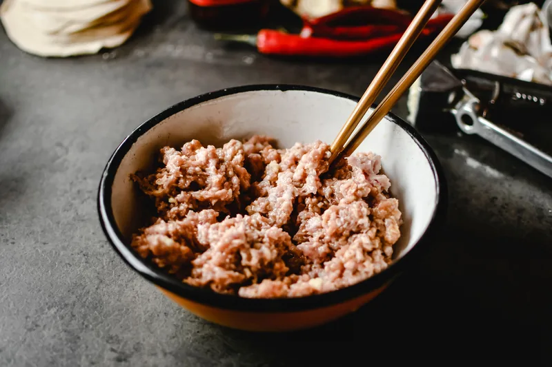 A bowl of ground pork with chopsticks