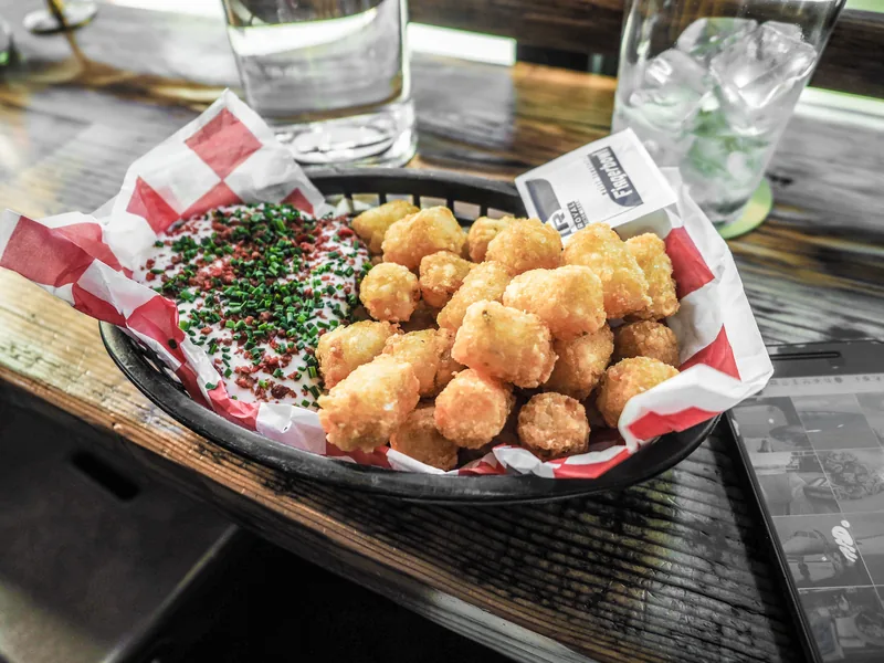 A basket of golden tater tots on checked paper