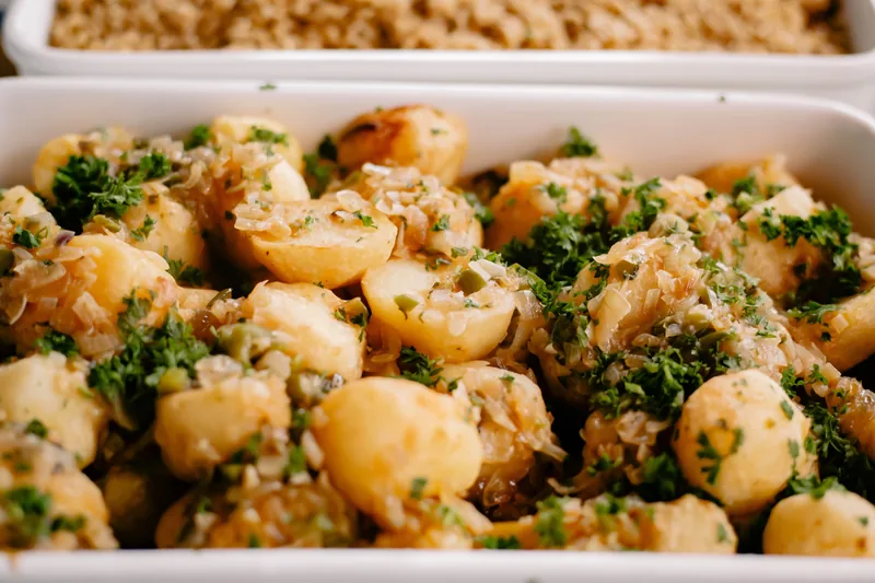 Baby potatoes in a dish scattered with chopped parsley