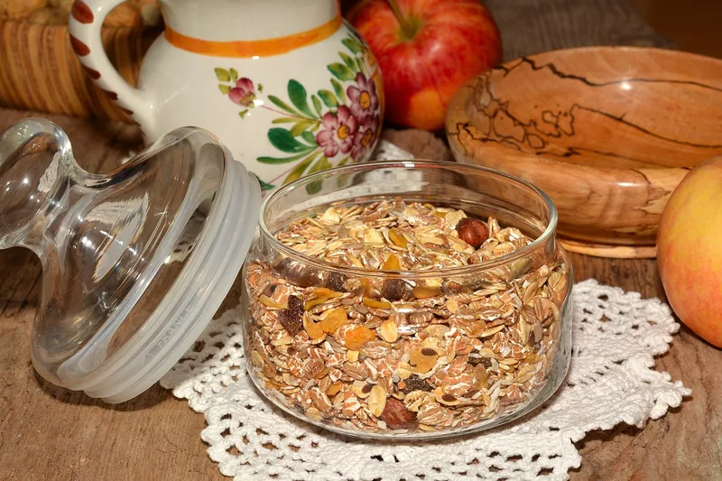 A jar of oats with an apple and a jug